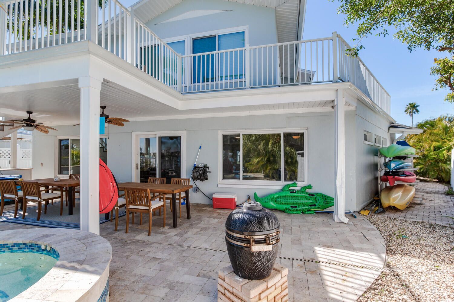 Une maison à deux étages dotée d’un patio couvert, d’un coin repas et d’une piscine.