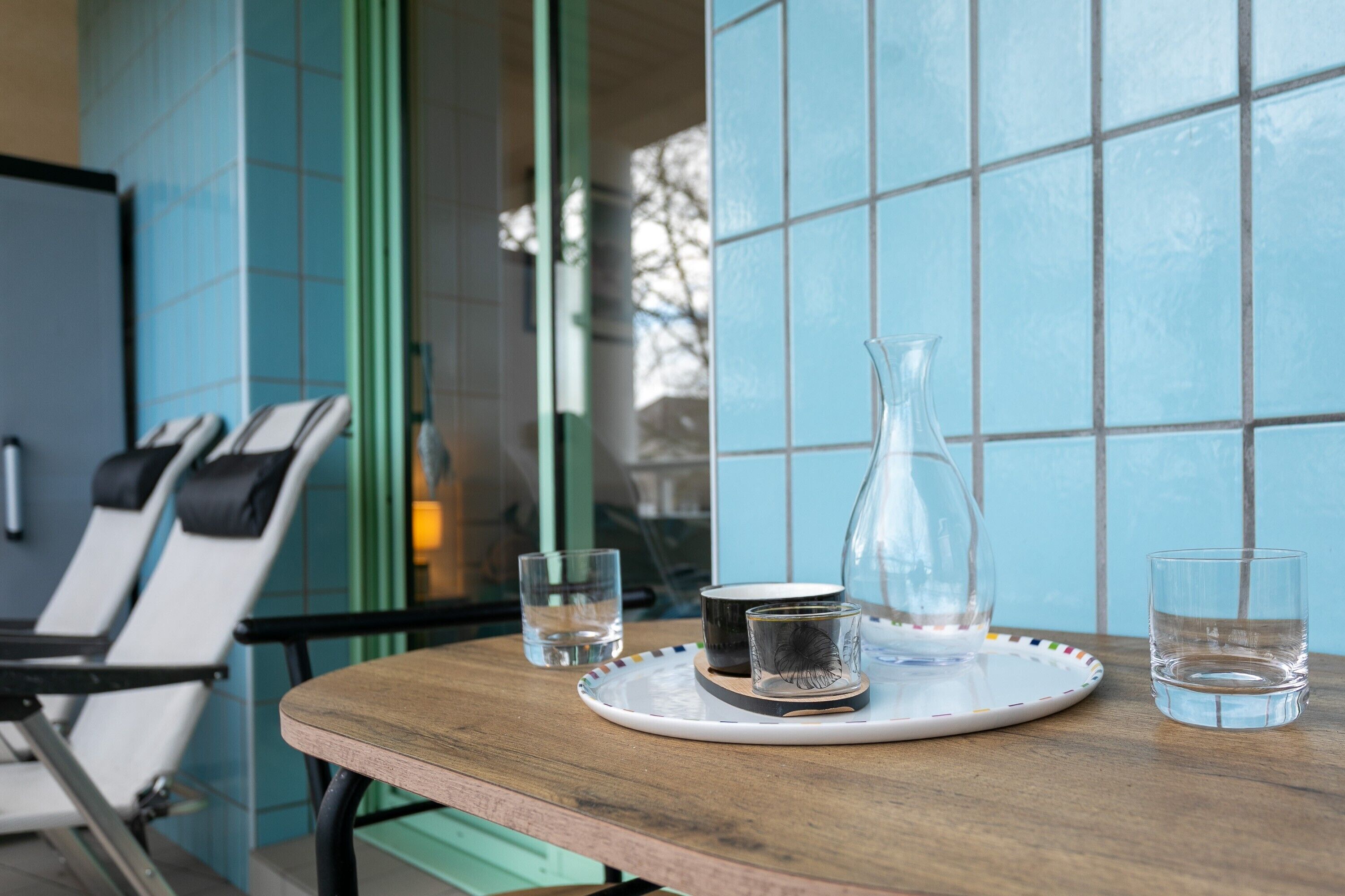 Une table avec un verre, une bouteille et une assiette contenant des verres.