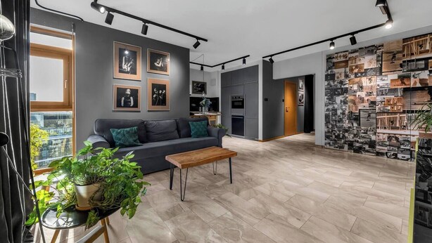 A modern living room with a grey sofa, a wooden coffee table, and a large window. - Muranów 14th Floor Apt - 62m2, Parking, Balcony - by Rentujemy (Warszawa)