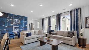 Uma sala de estar moderna com dois sofás, uma mesa de centro e um espelho grande.