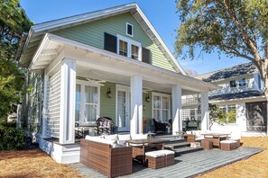 Charming green cottage with spacious covered porch featuring comfortable outdoor furniture for relaxing in the fresh air. - Stunning Pet Friendly Home Ravens Run (Miramar Beach)