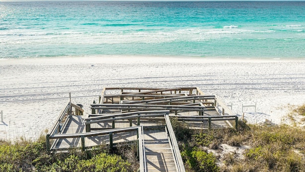 A wooden boardwalk leading to a beach with clear turquoise water and a sandy shore. - Remodeled Close to the Beach Islander 603 (Destin)
