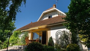 Ein Haus mit Ziegeldach, Schornstein und großem Fenster.