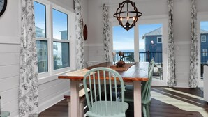 A dining area with a wooden table, chairs, and a chandelier. - The Lazy Turtle (Port St. Joe)