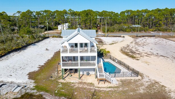 A two-story beachfront house with a pool, surrounded by sand and sparse vegetation. - Indian Shores Cottage (Port St. Joe)