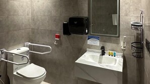 A modern bathroom with a toilet, sink, and mirror.