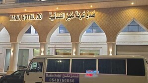 A building with a sign reading "MAKIN HOTEL.CO" and a van parked in front.