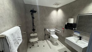 A modern bathroom with a shower, toilet, and sink.