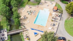 An aerial view of a resort with a swimming pool, lounge chairs, a bridge, and a dock. - “Evasion 52” Mobile Home with Shared Pool and Terrace (Saint-Gervais)