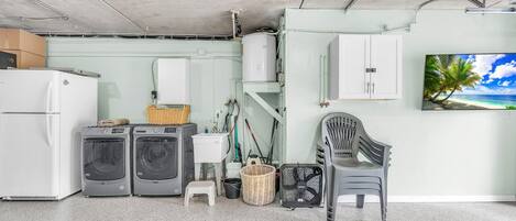 A laundry room with a washing machine, dryer, and a small step stool.