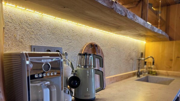 Una cocina con cafetera, tostadora y pileta.