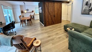 Amplia sala de estar con mesa de comedor, sillas, sofá y un gran armario de madera.