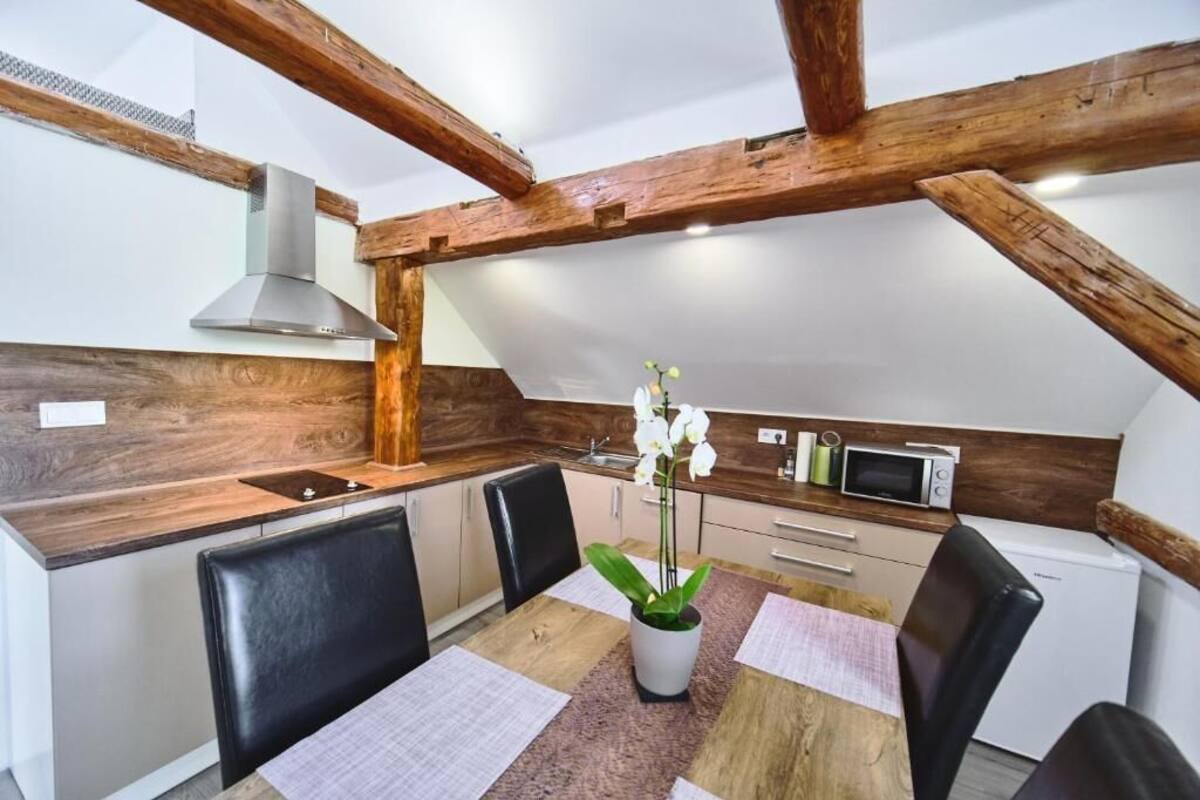 A compact kitchen with wooden beams, a microwave, and a sink.