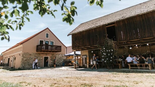 Un edificio rústico con fachada de piedra y estructura de madera con balcón.