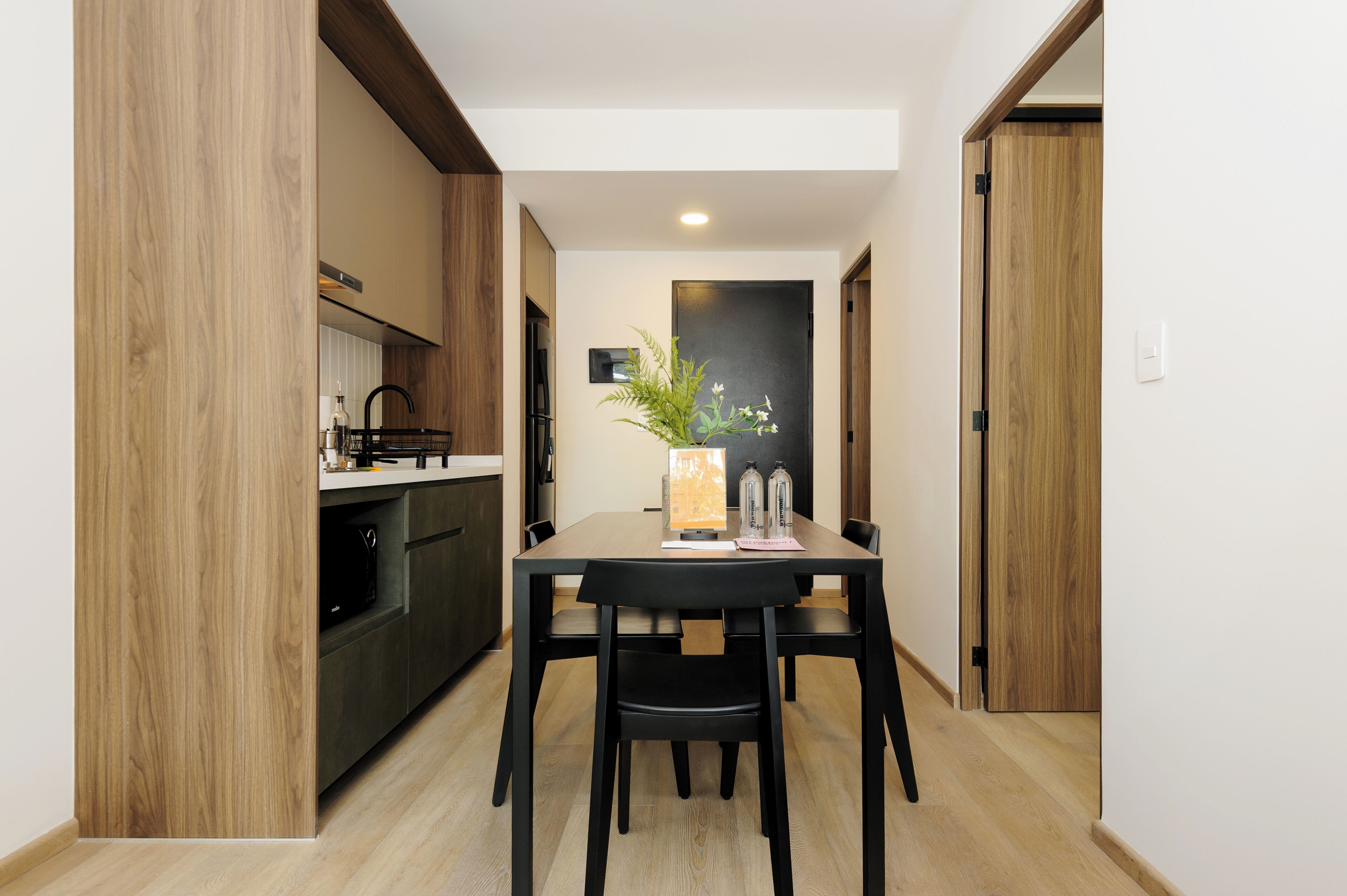 Een moderne keuken met houten kastjes en een eethoek met een tafel en stoelen.