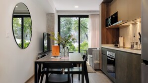 Una cocina moderna con comedor, ventanas amplias y vistas a zonas verdes.