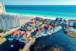 Ein Küstenresort mit Strandvillen, einem Jachthafen und einem großen Hotel.