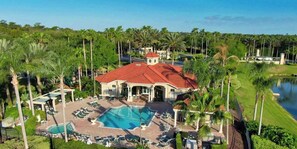 Ein Resort mit Swimmingpool, Liegestühlen und Palmen.