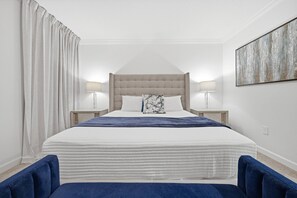 A bedroom with a large bed, two bedside lamps, a headboard, and a wall-mounted artwork. - 6BR house sleeps 14 with game room in davenport (Davenport)