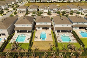 A residential area with multiple houses, a central swimming pool, and well-maintained lawns. - Encore Resort 5 Bedroom Home with Pool (2514) (Kissimmee)