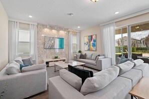 A modern living room with a sofa set, a coffee table, and artwork on the walls. - Encore Resort 5 Bedroom Home with Pool (2514) (Kissimmee)