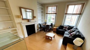 Un salon moderne doté d’une cheminée, d’un coin repas et d’un canapé agrémenté de coussins décoratifs.