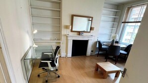 Un salon moderne avec une cheminée, une table en verre, une table basse en bois et un coin repas avec des chaises.