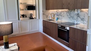 Eine moderne Küche mit weißen Schränken, einer Marmorarbeitsplatte und einem eingebauten Backofen.