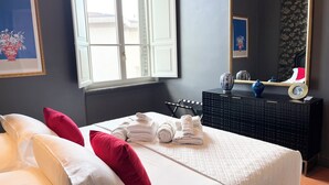 Ein Hotelzimmer mit Bett, Kissen, einem Schminktisch, einem Spiegel und einem Fenster.