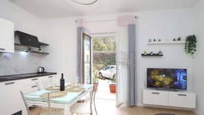 Una cocina moderna con comedor, televisor y vistas al exterior.