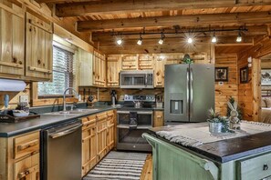 A wooden cabin-style kitchen with built-in appliances, a large island, and a rustic aesthetic. - Heavenly View Lodge | Ellijay, GA (Ellijay)