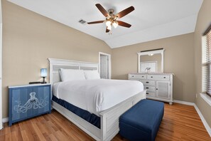 A bedroom with a bed, a ceiling fan, a dresser, and a nightstand. - Bay-View Delight / Sleeps 8 (Rockport)