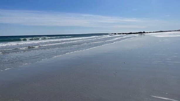 A wide beach with gentle waves and a clear sky. - Route3BnB (Shag Harbour)