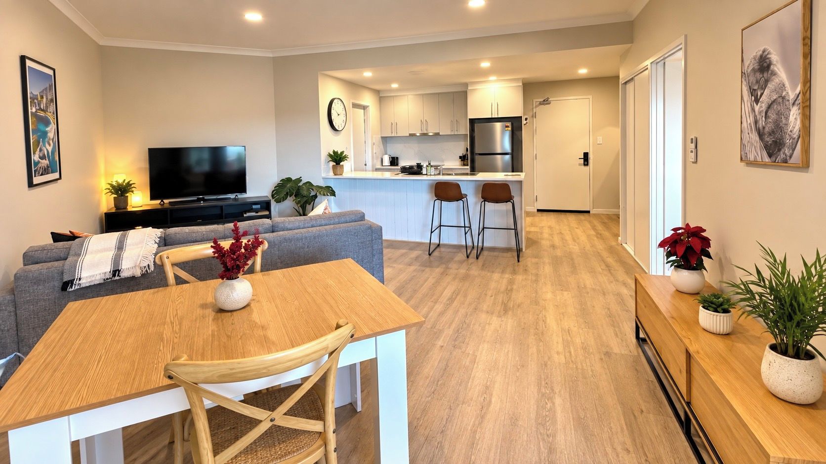 Una sala de estar moderna con sofá, mesa de comedor y televisor.
