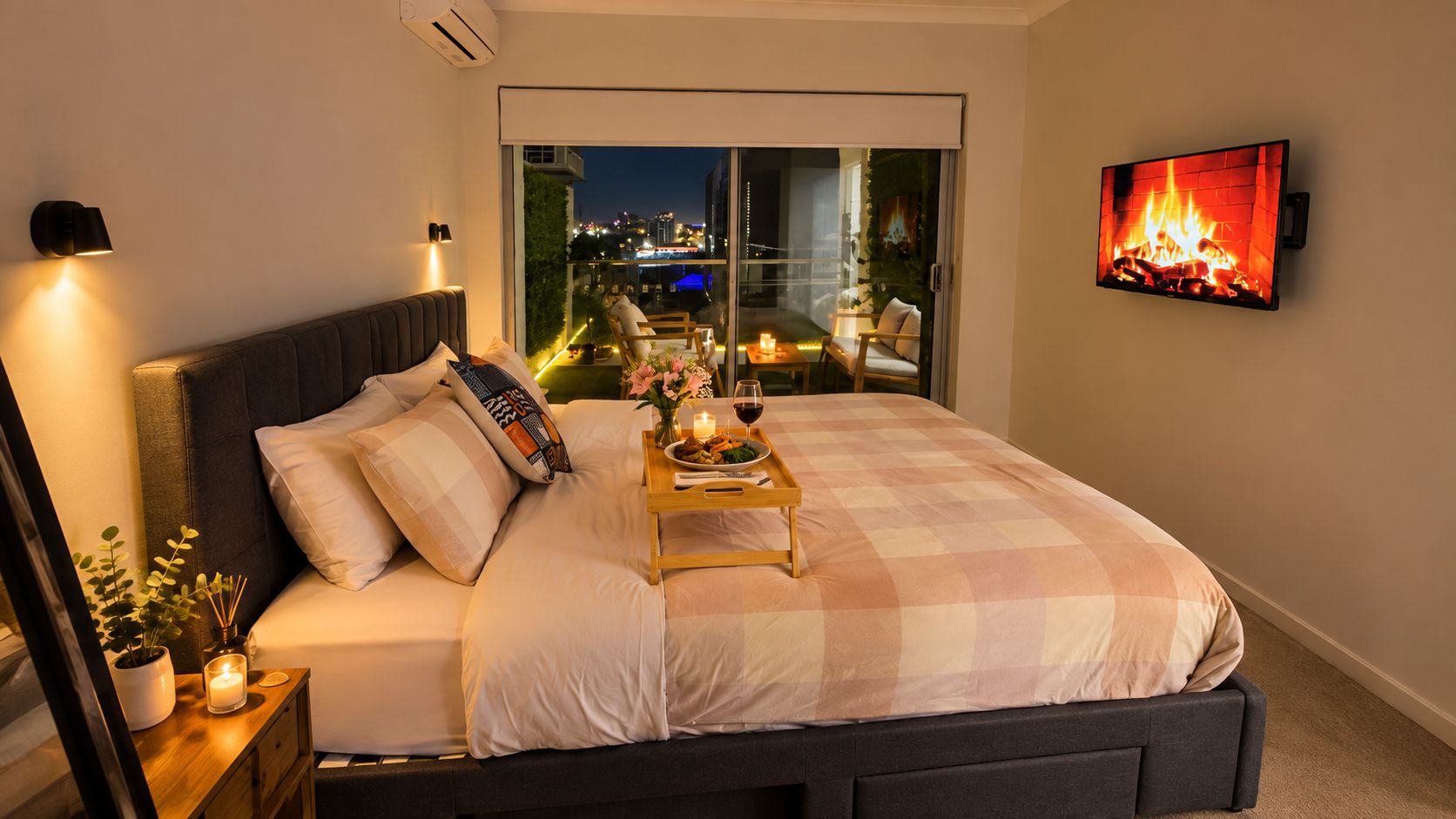Un dormitorio con cama, mesita de noche y televisor montado en la pared.