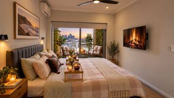 Un dormitorio con cama, mesita de noche y vistas a un paisaje urbano a través de una puerta corredera.