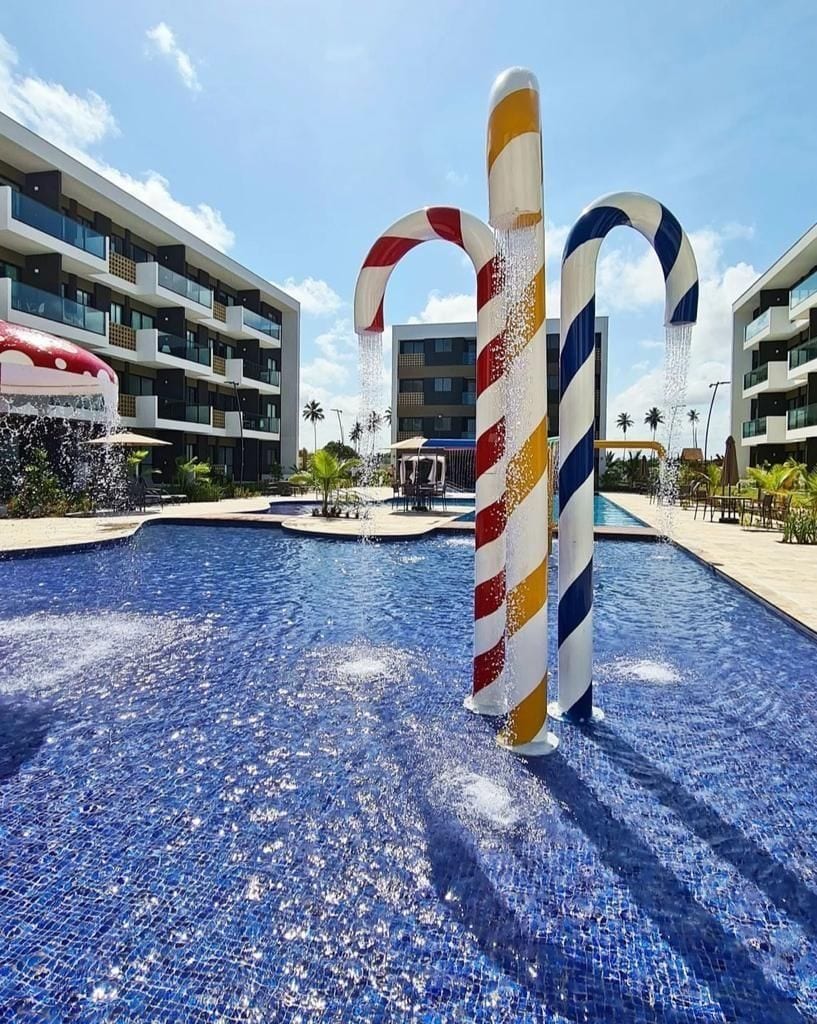 Piscina com duas colunas grandes e coloridas, em listras, no centro.
