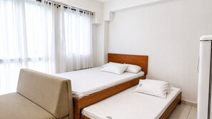 A hotel room with two single beds, a sofa, and a refrigerator. - FlatManaBeach (Ipojuca)