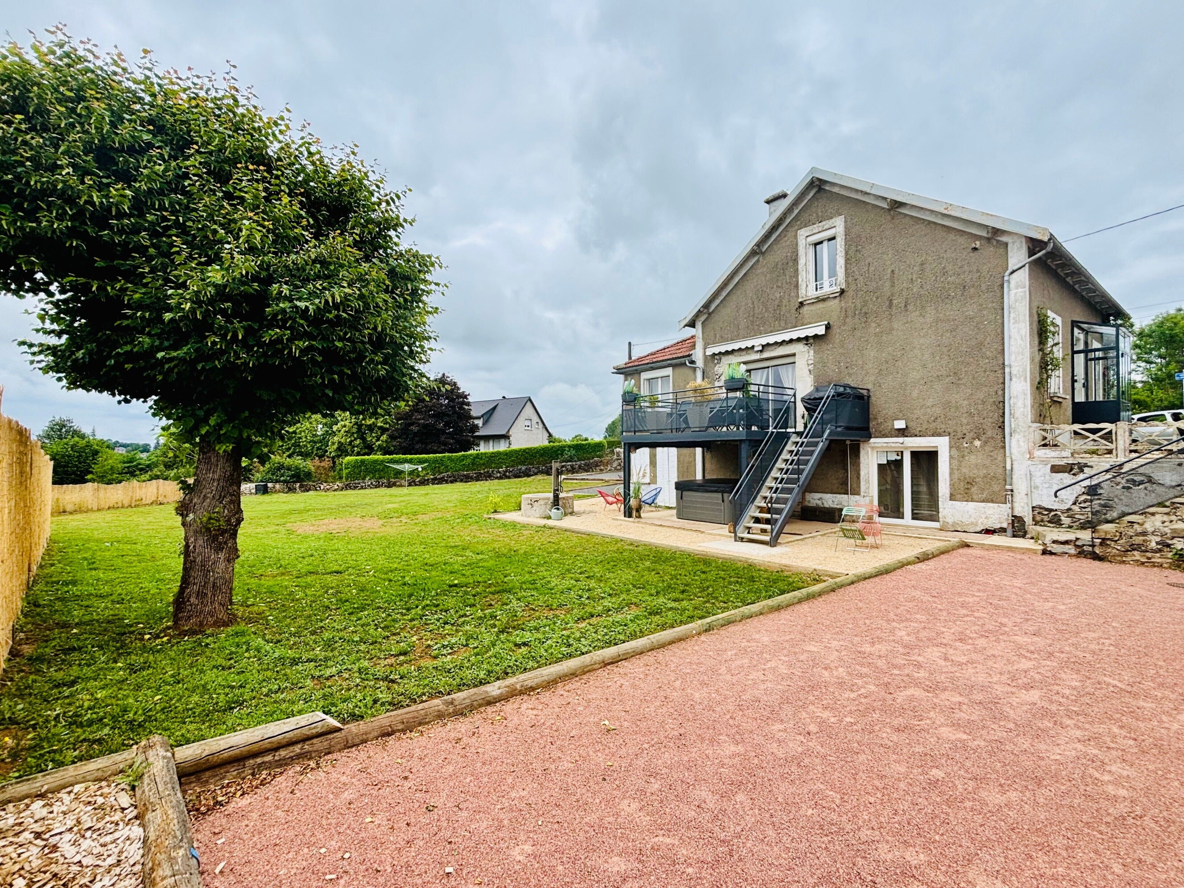 Un bâtiment à deux étages doté d’un balcon, d’un escalier et d’une allée pavée.