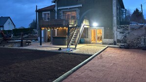 A two-story house with a balcony, a staircase, and a small outdoor area. - Chez Coco – 4★ Family Home, Jacuzzi & Games, Cantal (Mauriac)