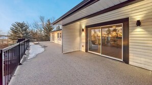 A covered outdoor area with a sliding glass door leading to a patio. - Walkout Bungalow with Pond Views (Delacour)