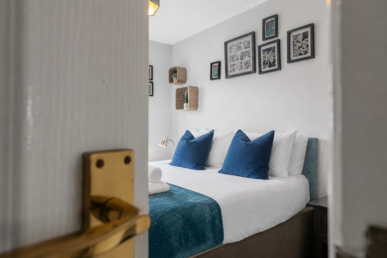 Una habitación de hotel con cama, escritorio y una pared decorada con cuadros.