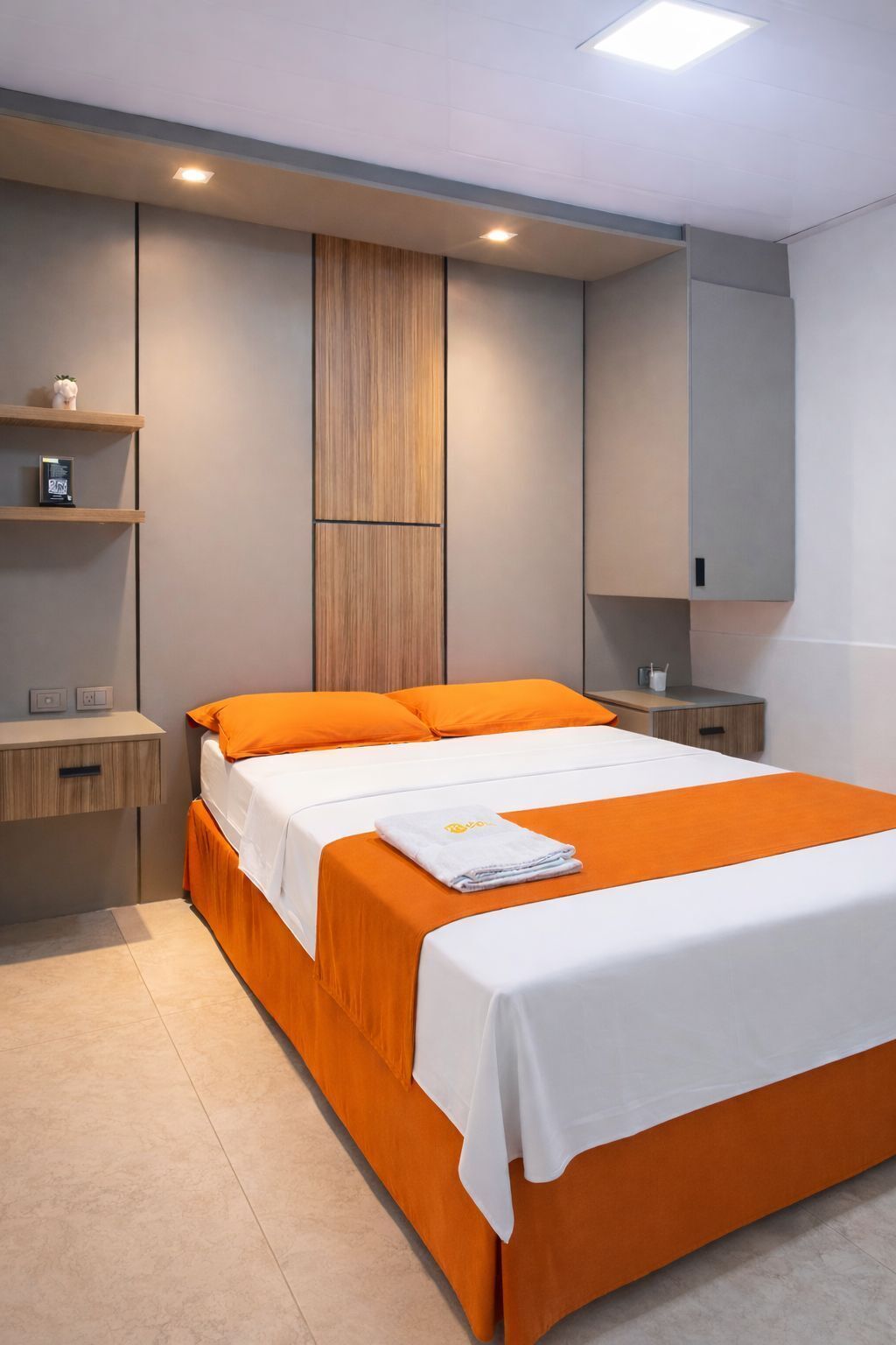 Une chambre moderne avec un grand lit, une literie orange, une tête de lit en bois et des étagères intégrées.