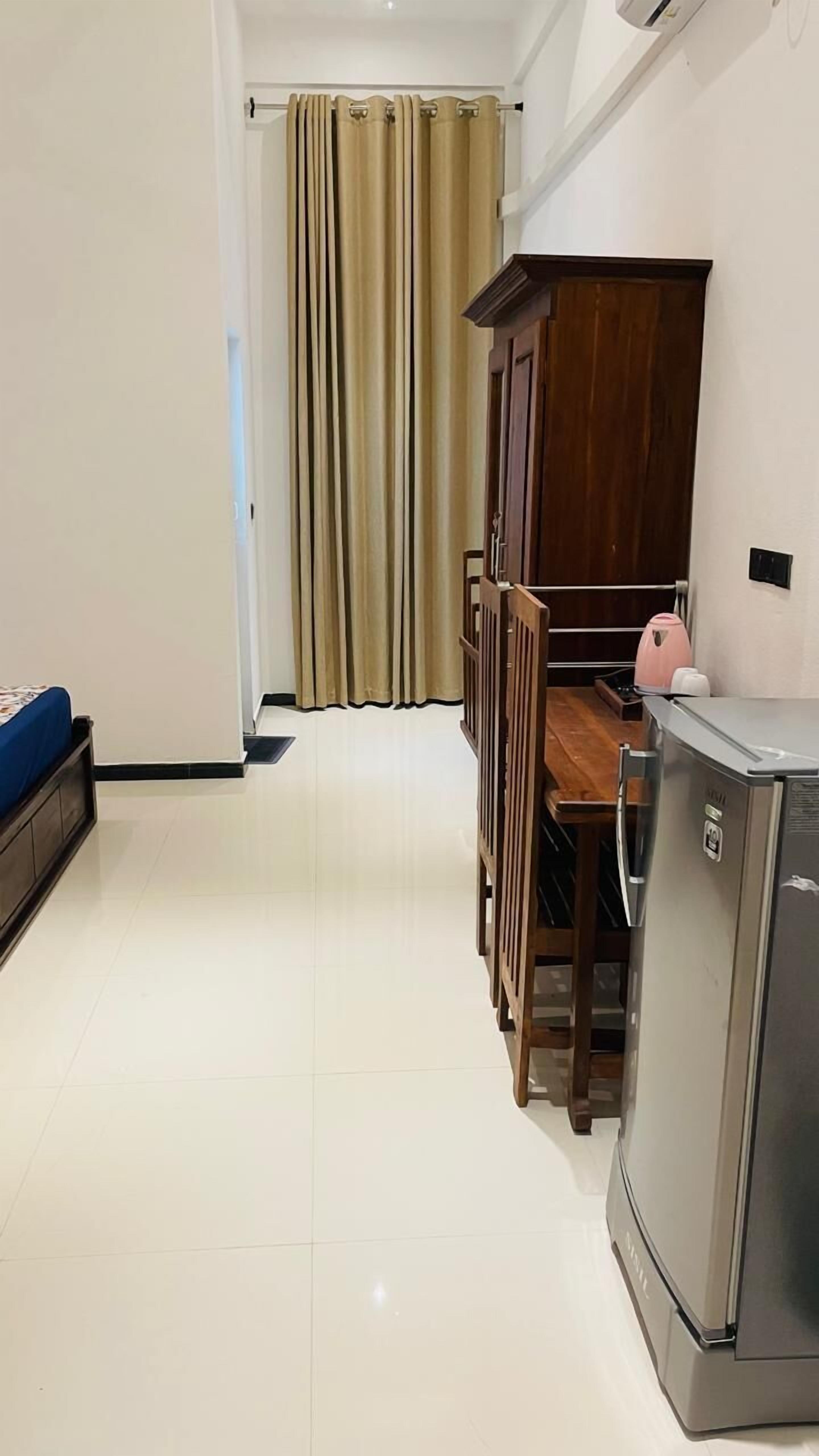 A compact living space with a kitchenette, a dining area, and a bed.