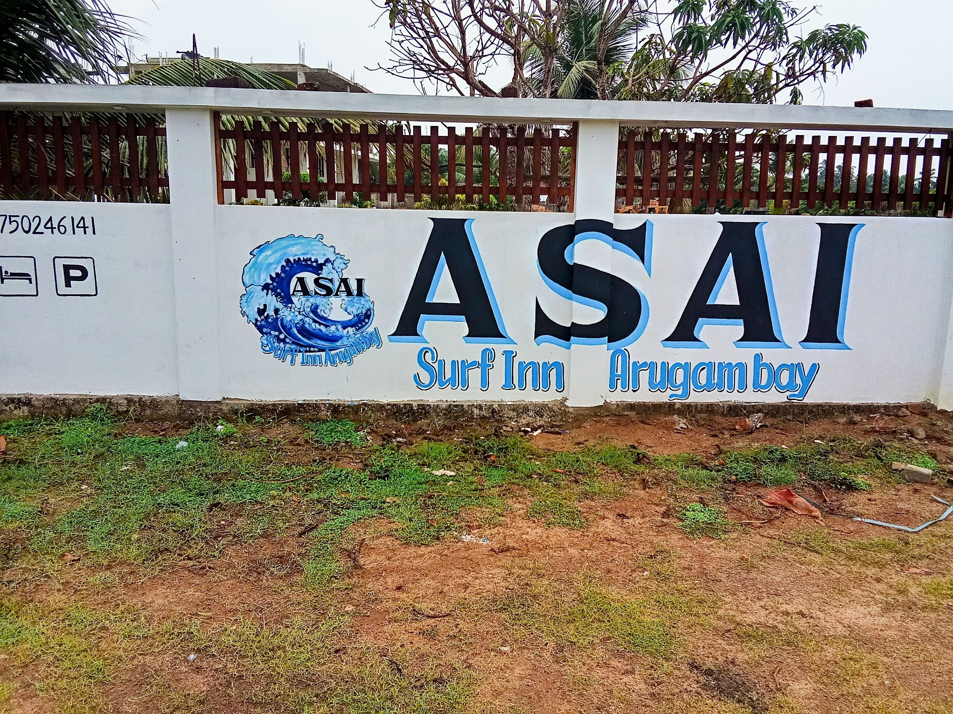 Paredes com o logotipo e nome ASAI Surf Inn, indicando um alojamento à beira-mar.