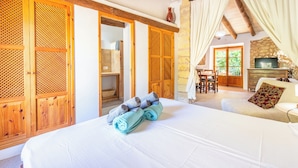 A bedroom with a bed, wooden wardrobe, and a dining area with a table and chairs. - Agroturismo Sa Vall de son Macia (Manacor)