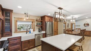 A modern kitchen with wooden cabinets, stainless steel appliances, and a large island.