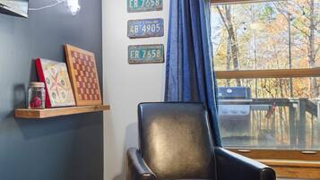 A room with a black leather chair, a window with a view of trees, and three South Carolina license plates on the wall.