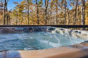 Ein Whirlpool mit Wasserstrahlen in einer natürlichen Umgebung, umgeben von Bäumen.