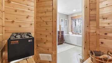 En stuga med träpanel på insidan, komplett med bastu, en träbänk och ett fönster med utsikt över omgivningen.